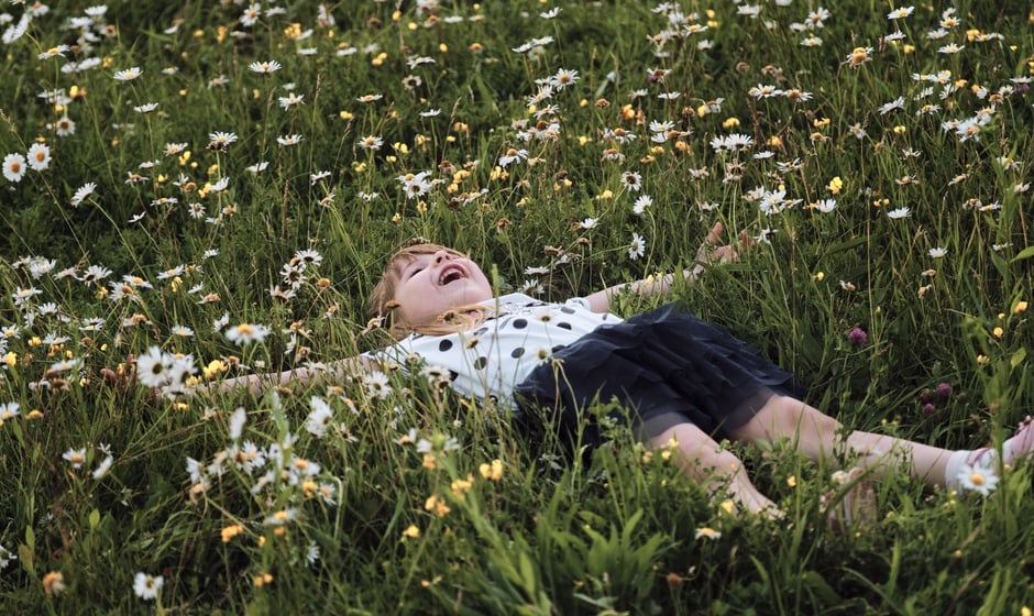 Kind liegt in bunter Blütenpracht