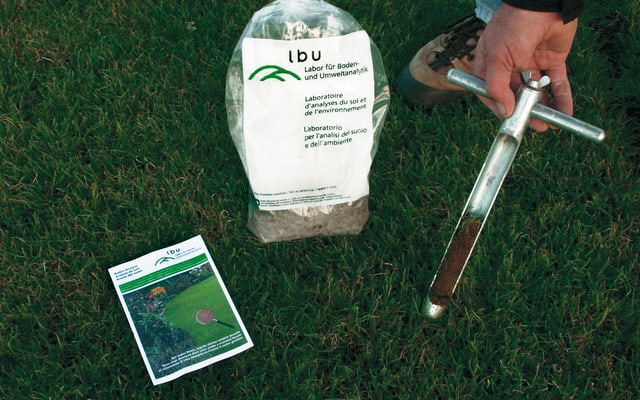 Entnahme einer Bodenprobe im Rasen mit einem speziellen Probenstecher